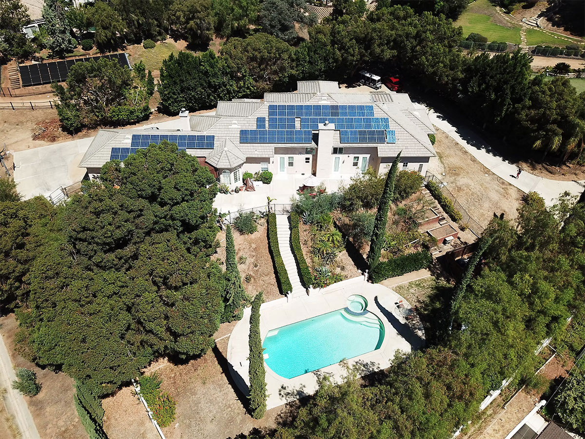 Ariel view of residence with solar panels and swimming pool
