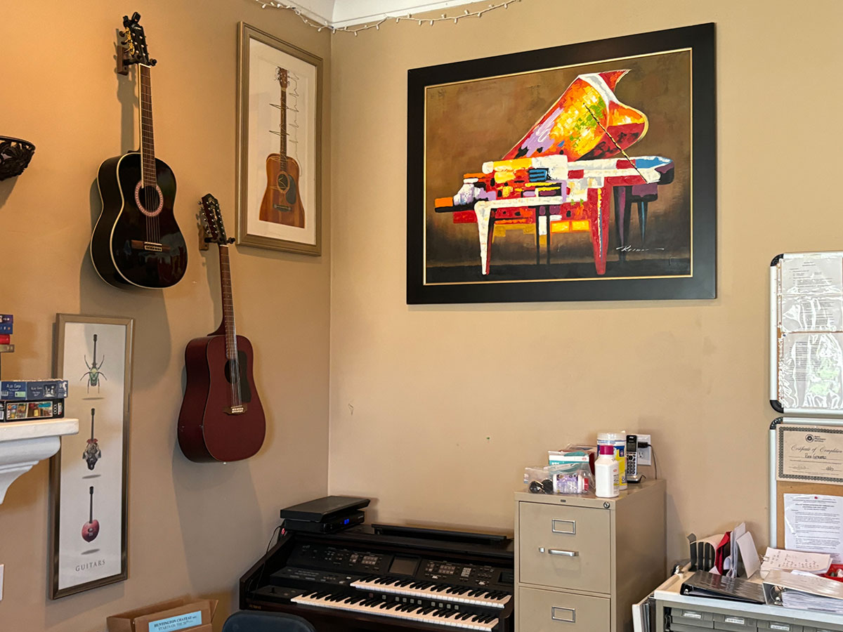 Piano with guitars and paintings on the walls